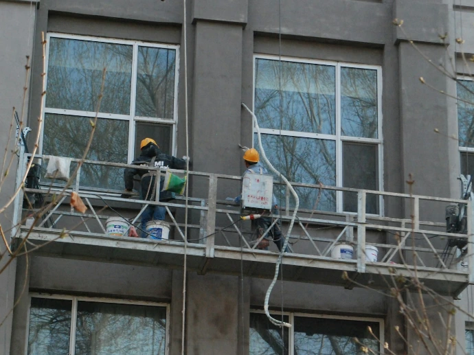 a couple of people standing on a balcony next to a tall building